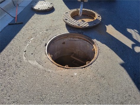 Open manhole with the frame lifted out beside it
