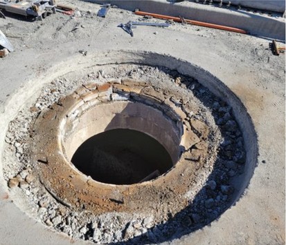 Round cut in the road with the old riser rings exposed