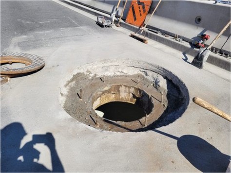 Excavated opening down to the top section of the manhole